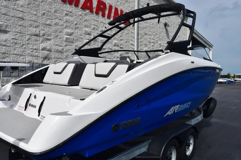 Slide: The Image of 2025 Yamaha Boats AR250 on trailer, sleek design, blue and white exterior. - 4