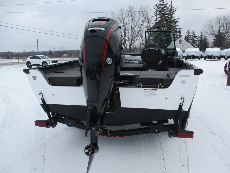 Slide: The Image of 2025 Lund Impact XS 1775 Sport boat with Mercury outboard motor on snowy ground. - 11