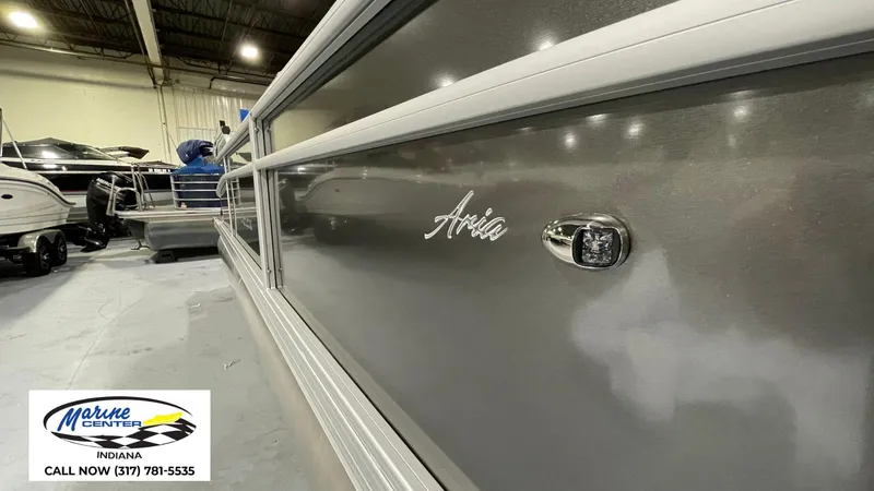 Slide: The Image of 2025 Barletta Aria A22QC pontoon boat in showroom, Marine Center Indiana contact info visible. - 24
