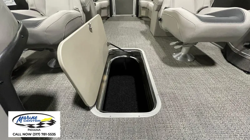 Slide: The Image of 2025 Barletta Aria A22QC interior with open storage compartment, gray seating, and carpeted floor. - 7
