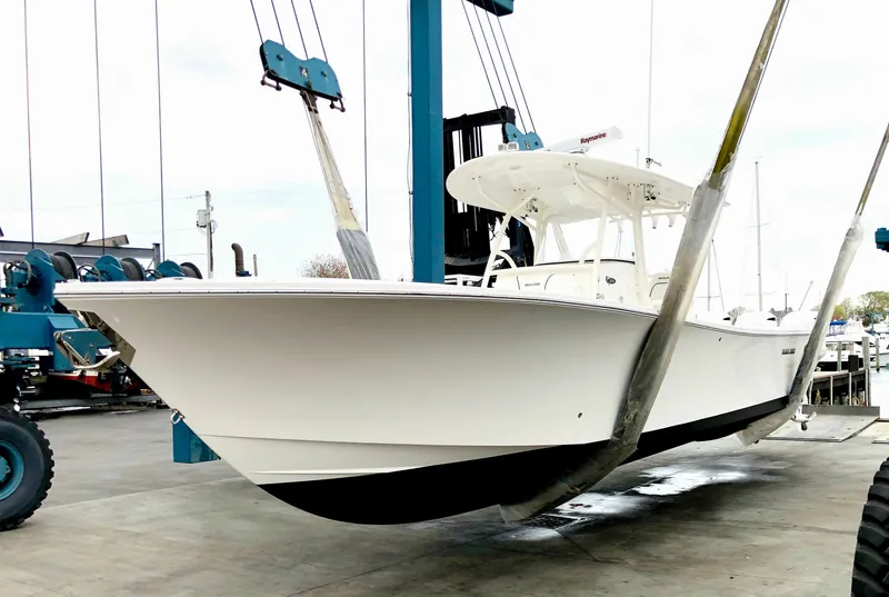 Slide: The Image of 2016 Regulator 34 boat in a marina lift, white hull, ready for launch. - 1