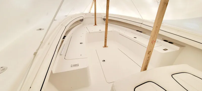 Slide: The Image of 2016 Regulator 34 boat interior under protective cover, showcasing spacious deck layout. - 11