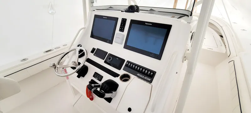 Slide: The Image of 2016 Regulator 34 boat dashboard with dual screens and steering wheel. - 5