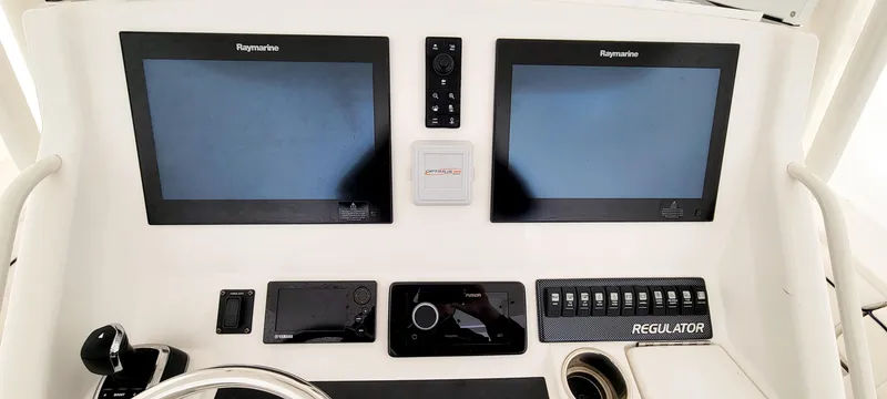 Slide: The Image of 2016 Regulator 34 boat dashboard with dual Raymarine displays and control panel. - 6