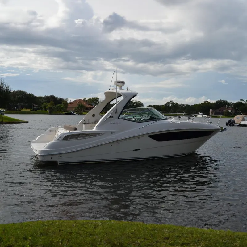 The Image of 2015 Sea Ray 330 Sundancer boat on a calm lake under cloudy skies. - 0