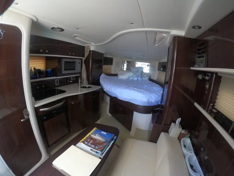 Slide: The Image of Interior of 2015 Sea Ray 330 Sundancer yacht with kitchen and bed area. - 12