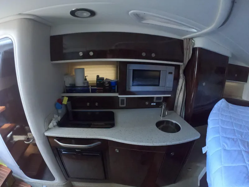 Slide: The Image of 2015 Sea Ray 330 Sundancer yacht interior kitchen with microwave and sink. - 14