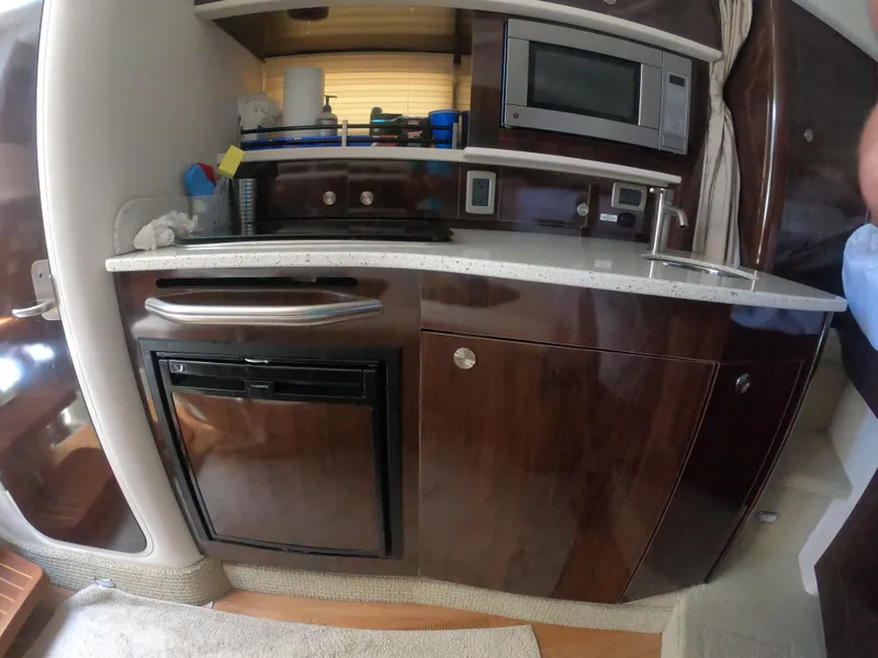 Slide: The Image of 2015 Sea Ray 330 Sundancer interior kitchen with microwave and mini fridge. - 15