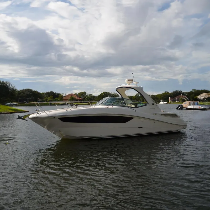 Slide: The Image of 2015 Sea Ray 330 Sundancer yacht on a calm lake under cloudy skies. - 2