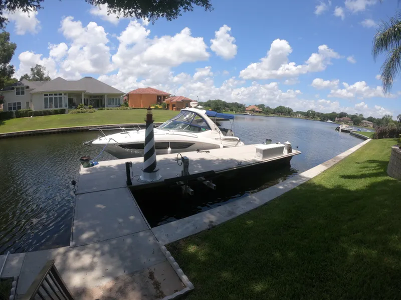 Slide: The Image of 2015 Sea Ray 330 Sundancer docked in a scenic residential canal. - 20