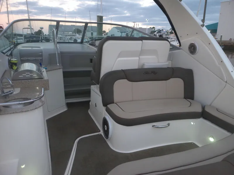 Slide: The Image of 2015 Sea Ray 330 Sundancer interior with seating and kitchenette at marina. - 29