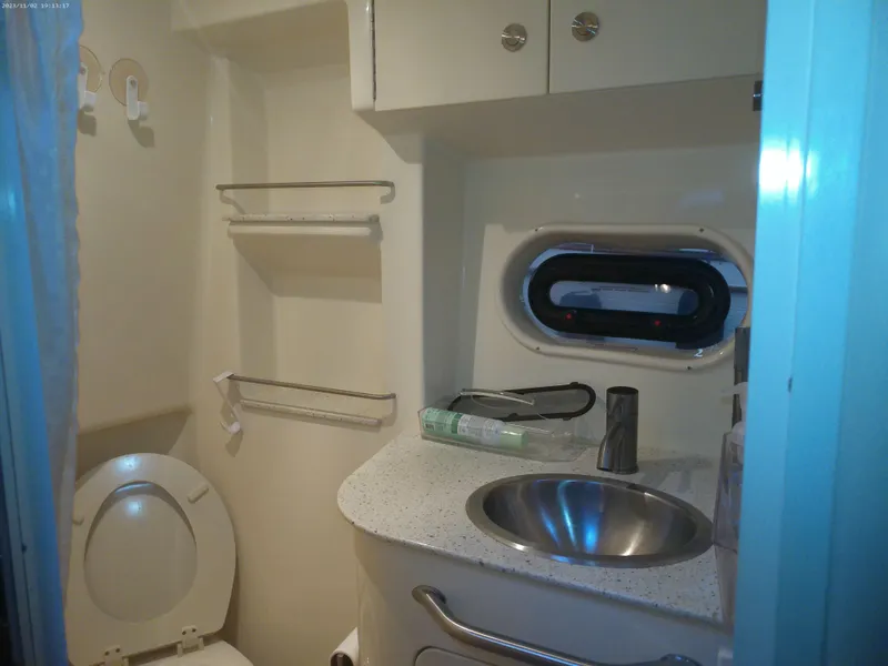 Slide: The Image of 2015 Sea Ray 330 Sundancer bathroom with sink, toilet, and storage shelves. - 41