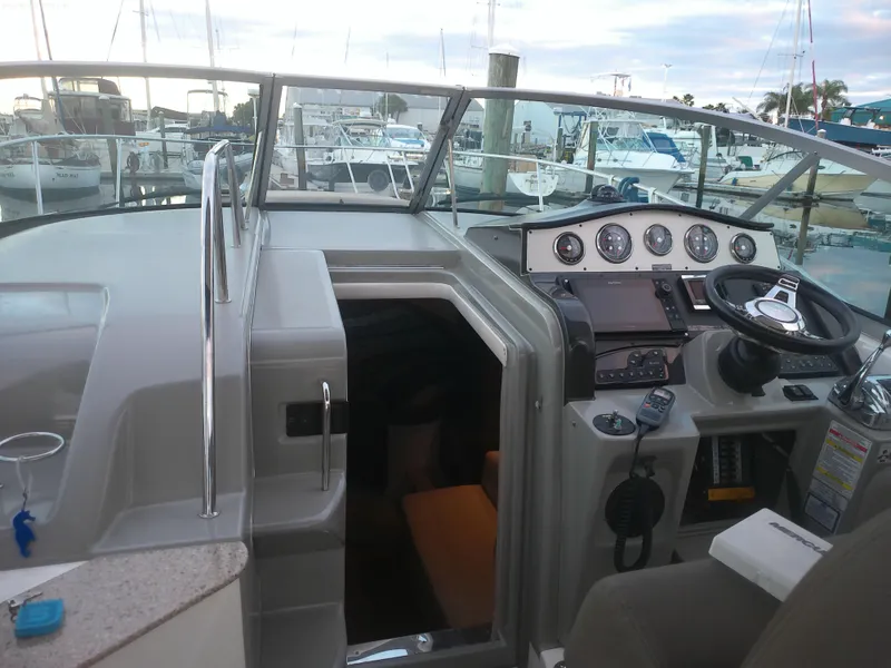 Slide: The Image of 2015 Sea Ray 330 Sundancer cockpit with helm and marina view. - 48