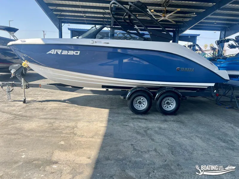 Slide: The Image of 2025 Yamaha Boats AR220 in blue on trailer under shelter. - 0