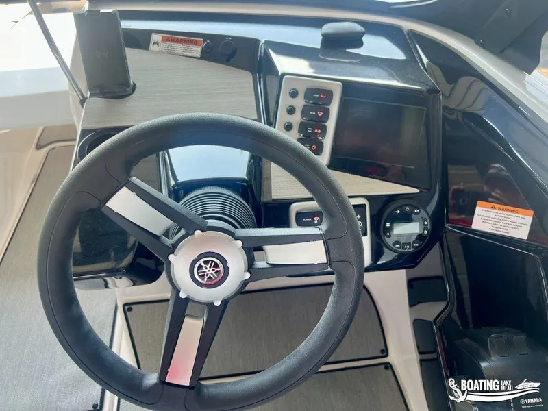 Slide: The Image of 2025 Yamaha AR220 boat dashboard with steering wheel and control panel. - 12