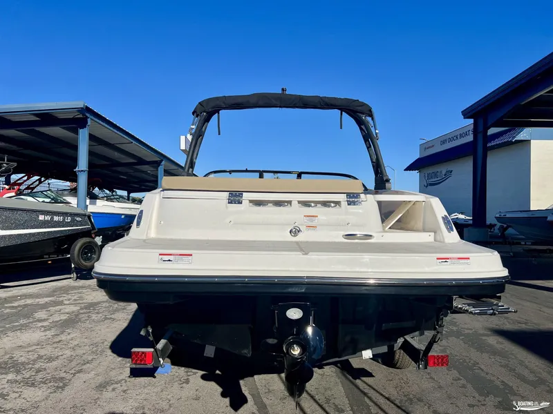 Slide: The Image of 2025 Bayliner VR5 boat rear view in marina under clear blue sky. - 2
