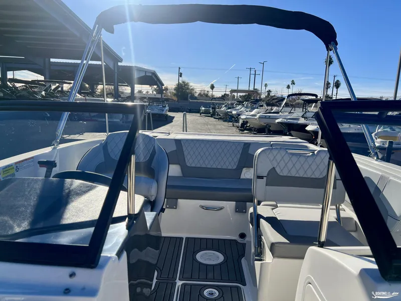 Slide: The Image of 2025 Bayliner VR5 boat interior with seating and canopy in a marina setting. - 3