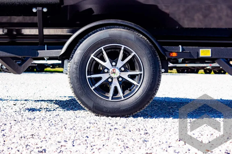 Slide: The Image of 2025 G3 Sportsman 1710 trailer wheel on gravel surface. - 18