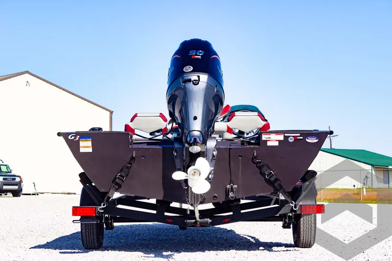 Slide: The Image of 2025 G3 Sportsman 1710 boat, rear view with motor, parked on gravel. - 20