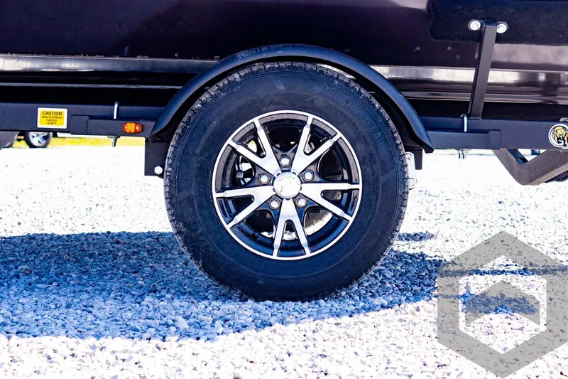 Slide: The Image of 2025 G3 Sportsman 1710 trailer wheel on gravel surface. - 23