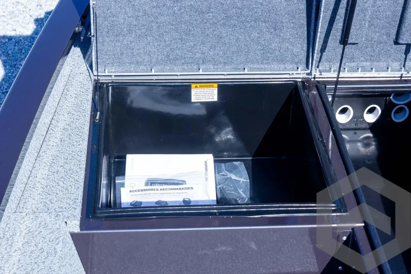 Slide: The Image of Open storage compartment in 2025 G3 Sportsman 1710 boat, showing interior space and manual. - 42