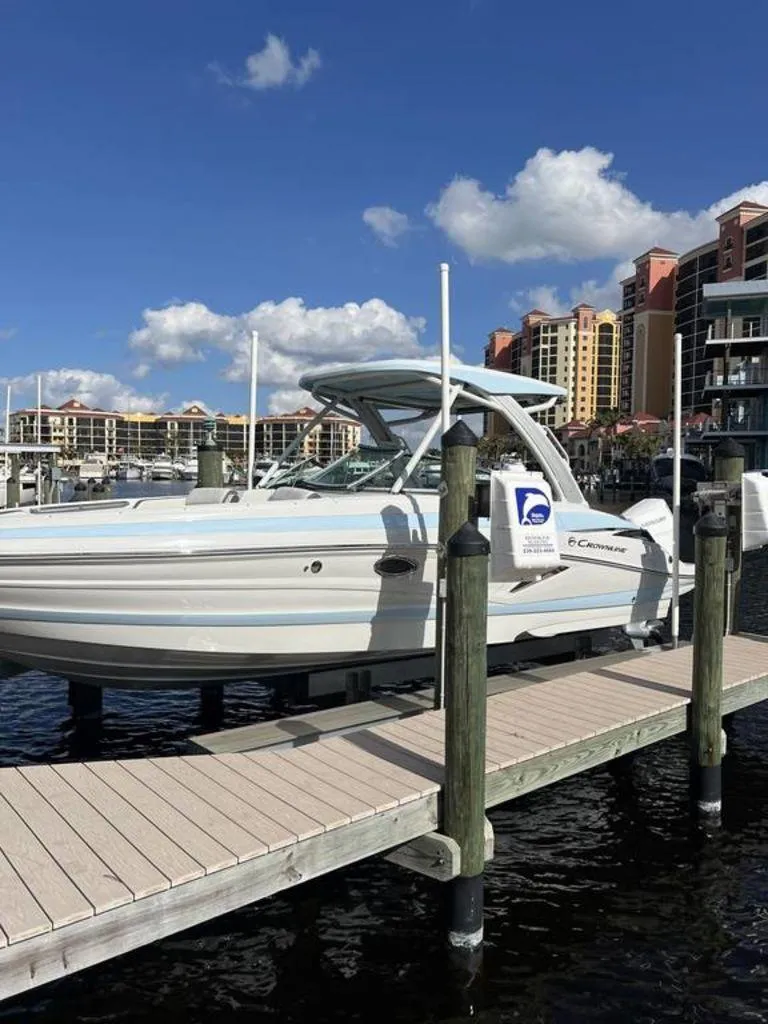 Slide: The Image of 2025 Crownline 290 XSS boat docked at marina under blue sky. - 1