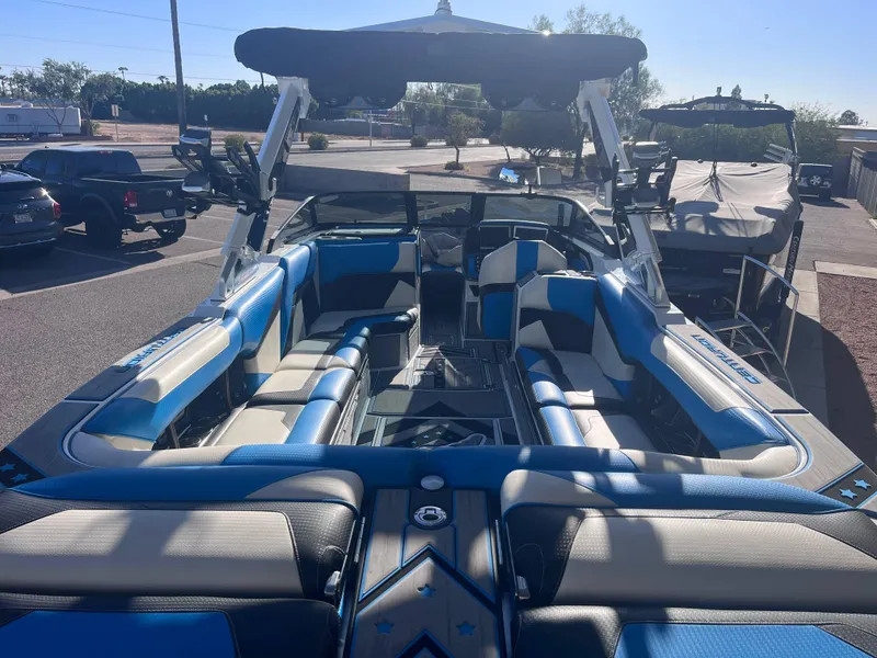 Slide: The Image of 2022 Centurion Ri265 boat interior with blue and gray seating in a parking lot. - 5