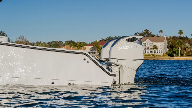 Slide: The Image of Freeman 34VH 2020 boat with Suzuki engine on water near shoreline homes. - 2