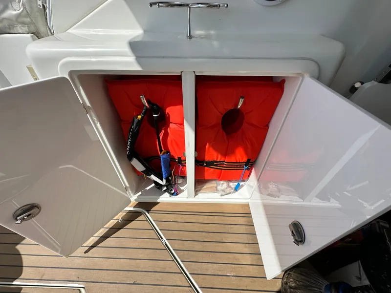 Slide: The Image of Open storage compartment on 2009 Cruisers Yachts 420 Express with life jackets inside. - 10