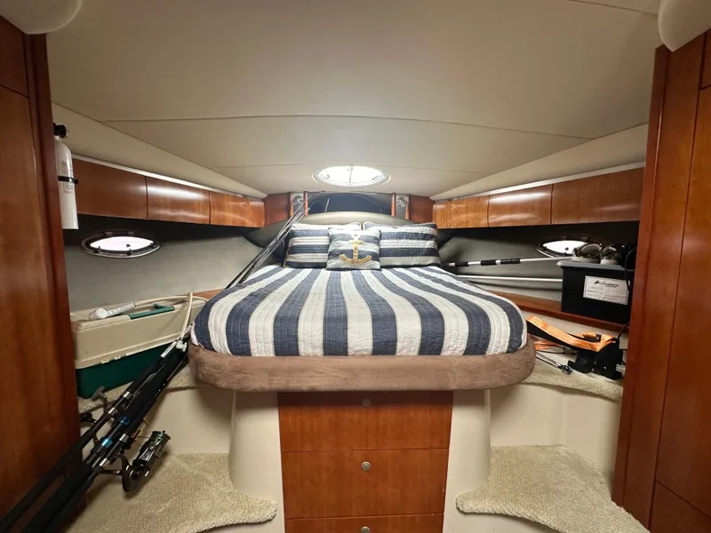Slide: The Image of Interior cabin of 2009 Cruisers Yachts 420 Express with striped bedding and wooden cabinetry. - 28