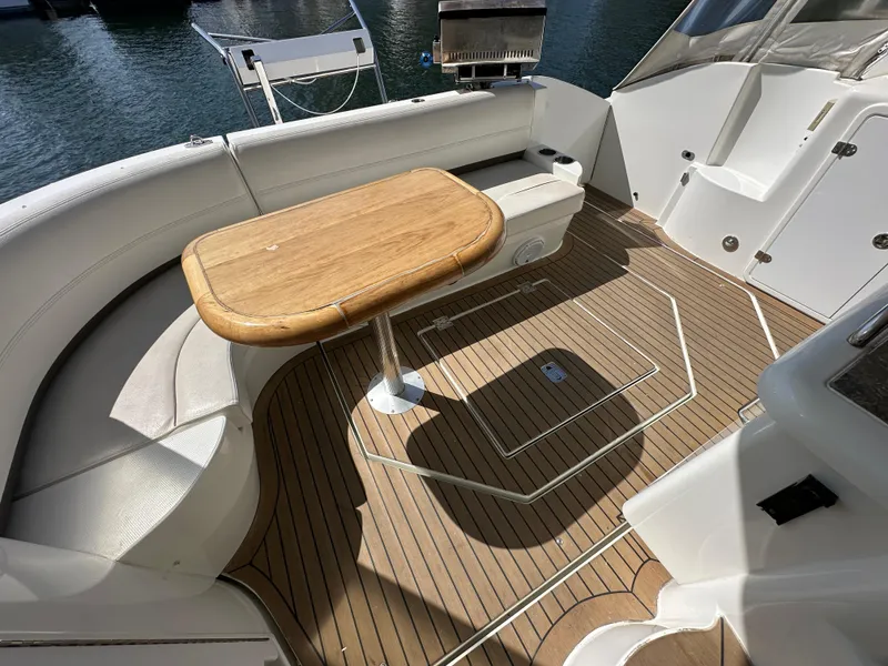 Slide: The Image of 2009 Cruisers Yachts 420 Express cockpit with teak flooring and wooden table. - 3