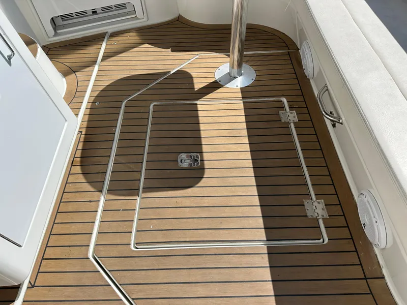 Slide: The Image of 2009 Cruisers Yachts 420 Express deck with wood finish and storage hatch. - 6