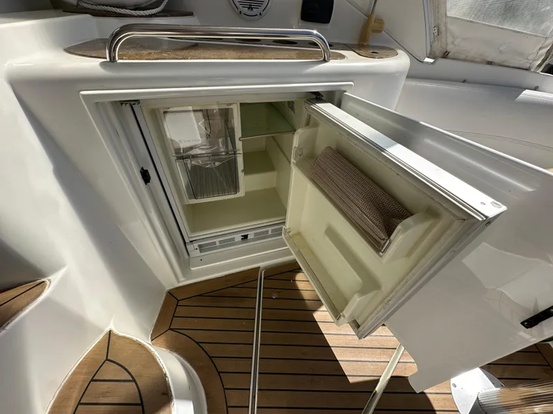 Slide: The Image of 2009 Cruisers Yachts 420 Express interior with open mini fridge on teak deck. - 8