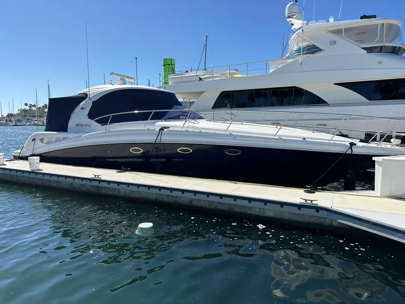 Slide: The Image of 2005 Sea Ray 420 Sundancer yacht docked at marina under clear blue sky. - 4