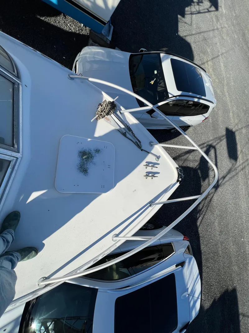 Slide: The Image of Aerial view of 1973 Bertram 31 Flybridge Cruiser docked near two cars. - 11