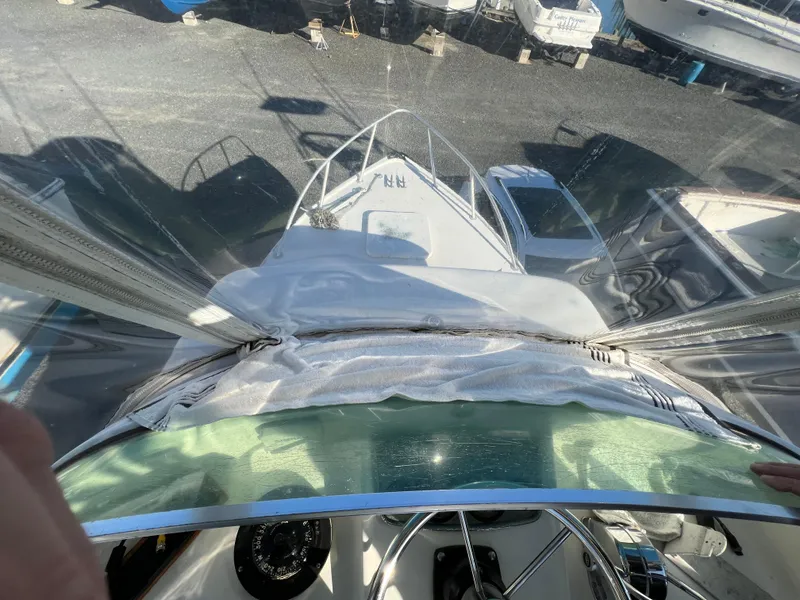 Slide: The Image of 1973 Bertram 31 Flybridge Cruiser view from helm, docked with other boats. - 13