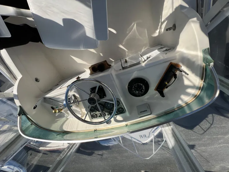Slide: The Image of 1973 Bertram 31 Flybridge Cruiser helm with steering wheel and controls. - 14