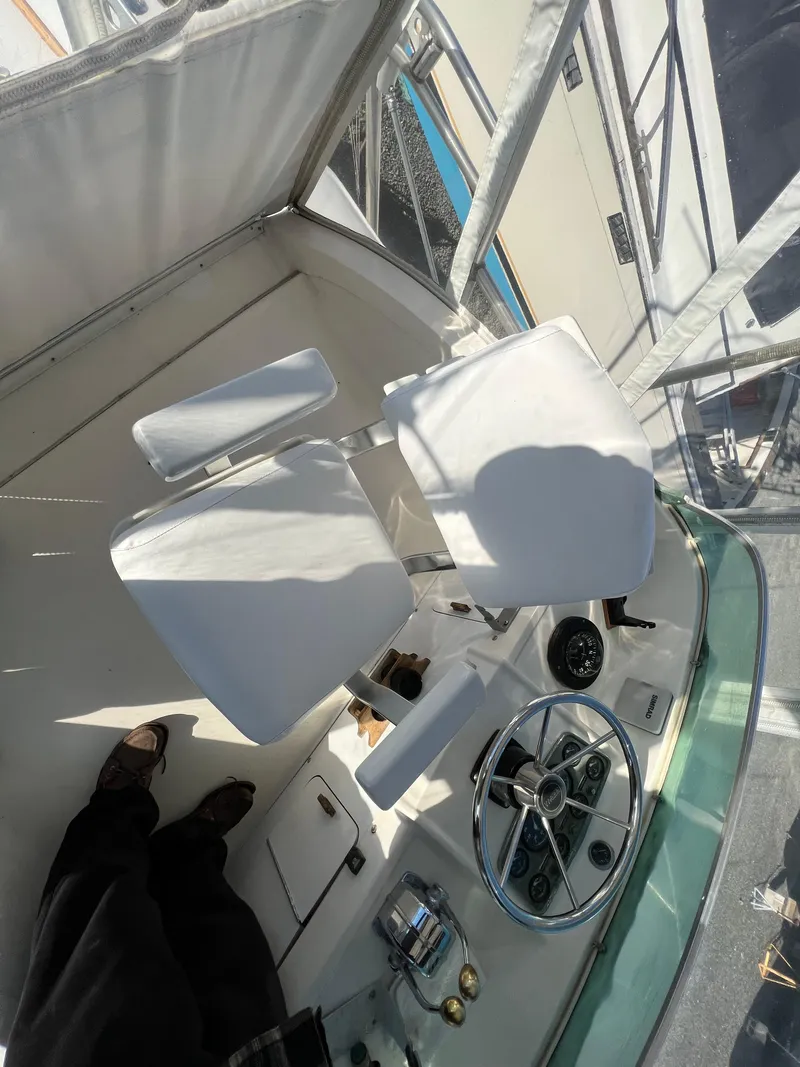 Slide: The Image of 1973 Bertram 31 Flybridge Cruiser helm with white seats and steering wheel. - 16
