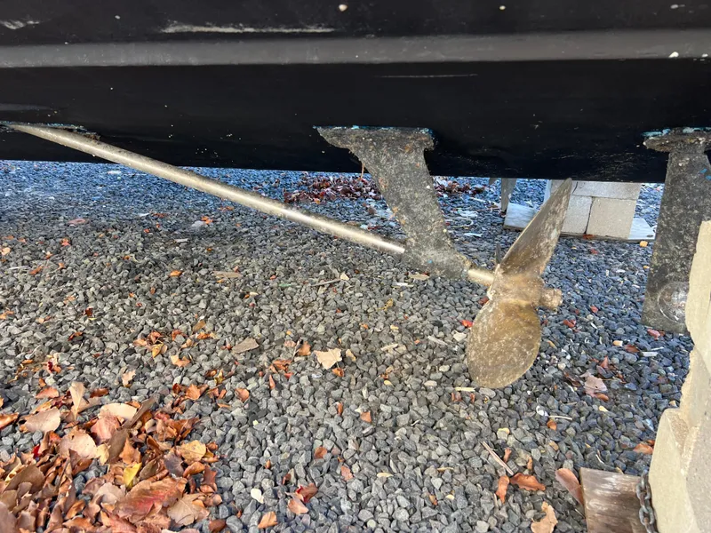 Slide: The Image of 1973 Bertram 31 Flybridge Cruiser propeller and shaft on gravel with autumn leaves. - 19