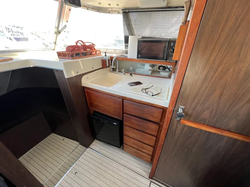 Slide: The Image of Interior of 1973 Bertram 31 Flybridge Cruiser with kitchenette and wooden cabinetry. - 25