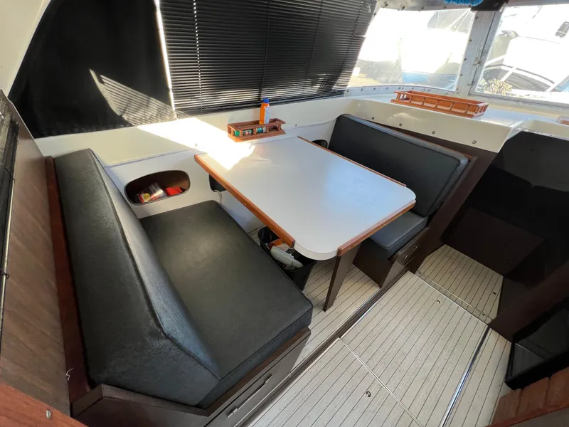 Slide: The Image of Interior of 1973 Bertram 31 Flybridge Cruiser with dining area and black seating. - 26