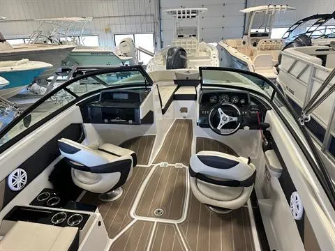 Slide: The Image of 2023 Monterey M-225 boat interior with modern seating and dashboard in showroom. - 6