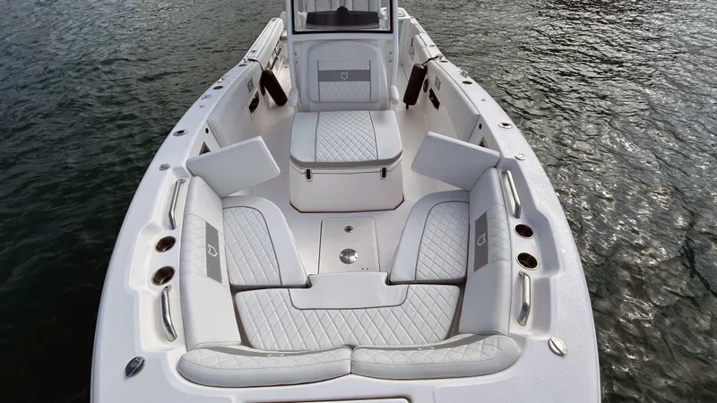 Slide: The Image of 2024 Sea Fox 268 Commander boat interior with cushioned seating on water. - 11