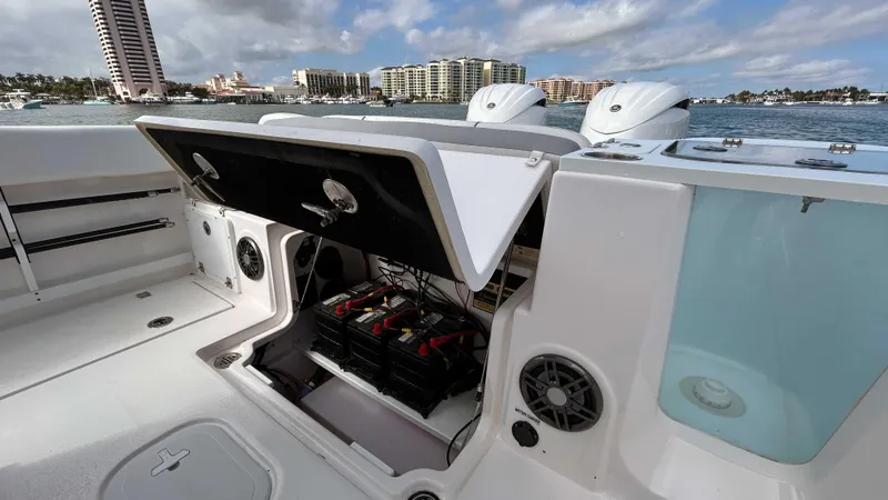 Slide: The Image of 2024 Sea Fox 268 Commander boat with open storage compartment, docked near waterfront buildings. - 22