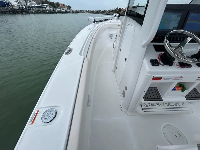 Slide: The Image of 2024 Sea Hunt Gamefish 27 boat interior, featuring helm and spacious deck. - 10