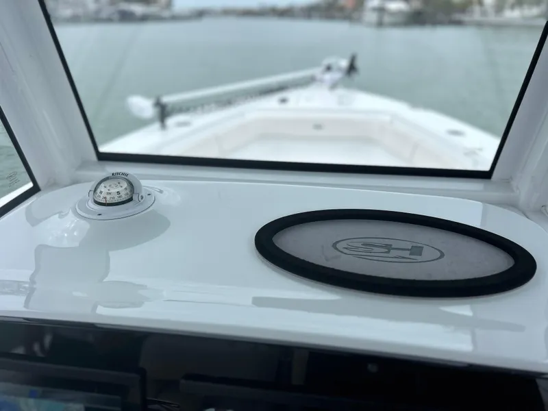 Slide: The Image of 2024 Sea Hunt Gamefish 27 dashboard view with compass and waterway in background. - 17