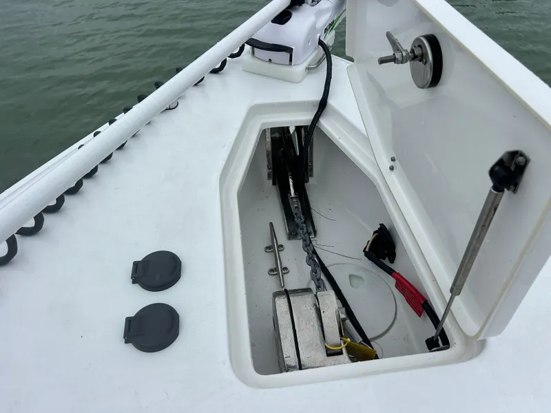 Slide: The Image of 2024 Sea Hunt Gamefish 27 anchor storage compartment with open lid, showing interior details. - 27