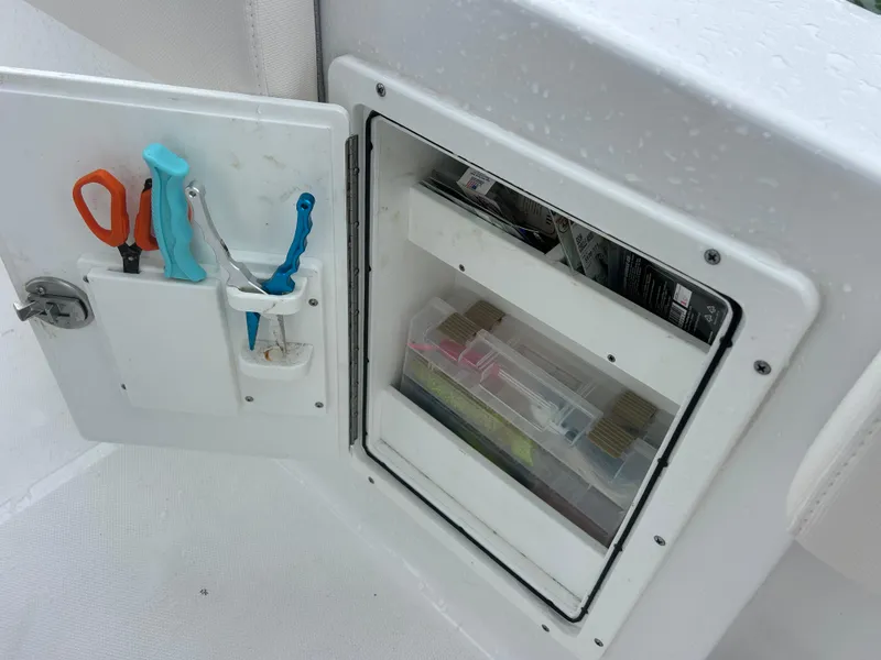 Slide: The Image of Storage compartment with tools and tackle boxes on a 2024 Sea Hunt Gamefish 27 boat. - 40