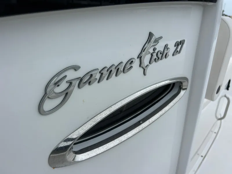 Slide: The Image of 2024 Sea Hunt Gamefish 27 logo on white boat surface. - 43