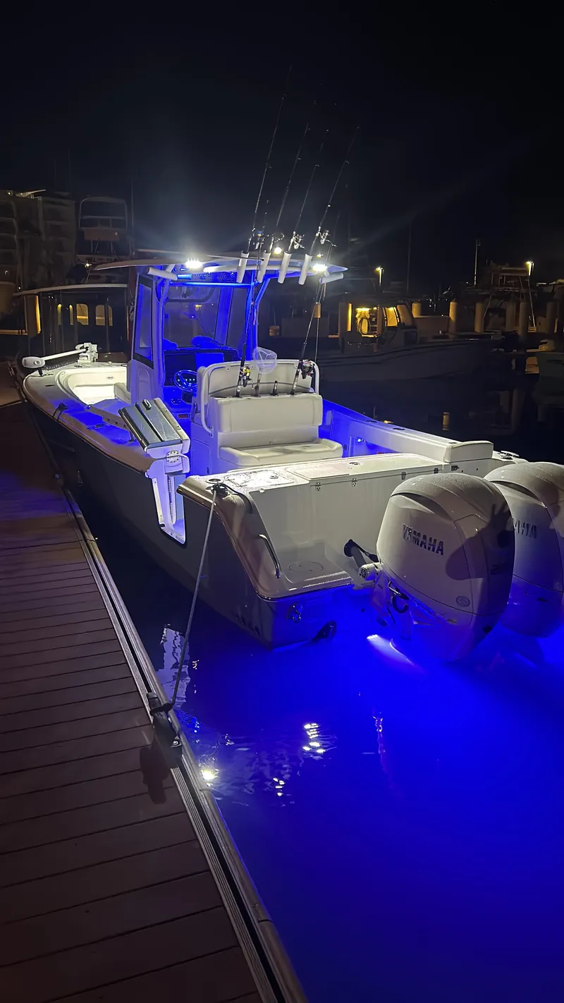 Slide: The Image of 2024 Sea Hunt Gamefish 27 with Coffin Box, illuminated at night, docked with Yamaha engines. - 46